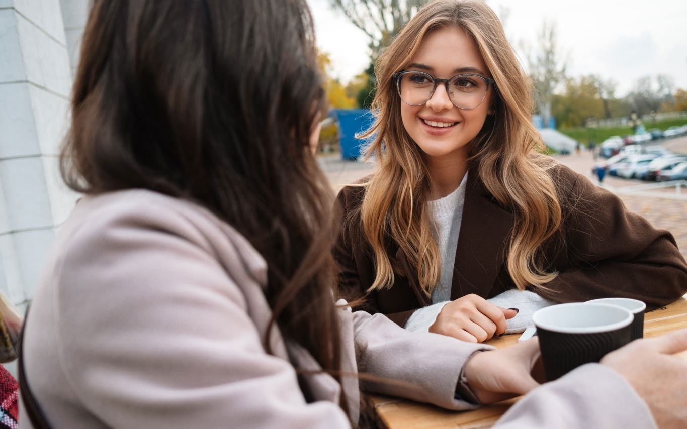 To unge i samtale med kaffekrus