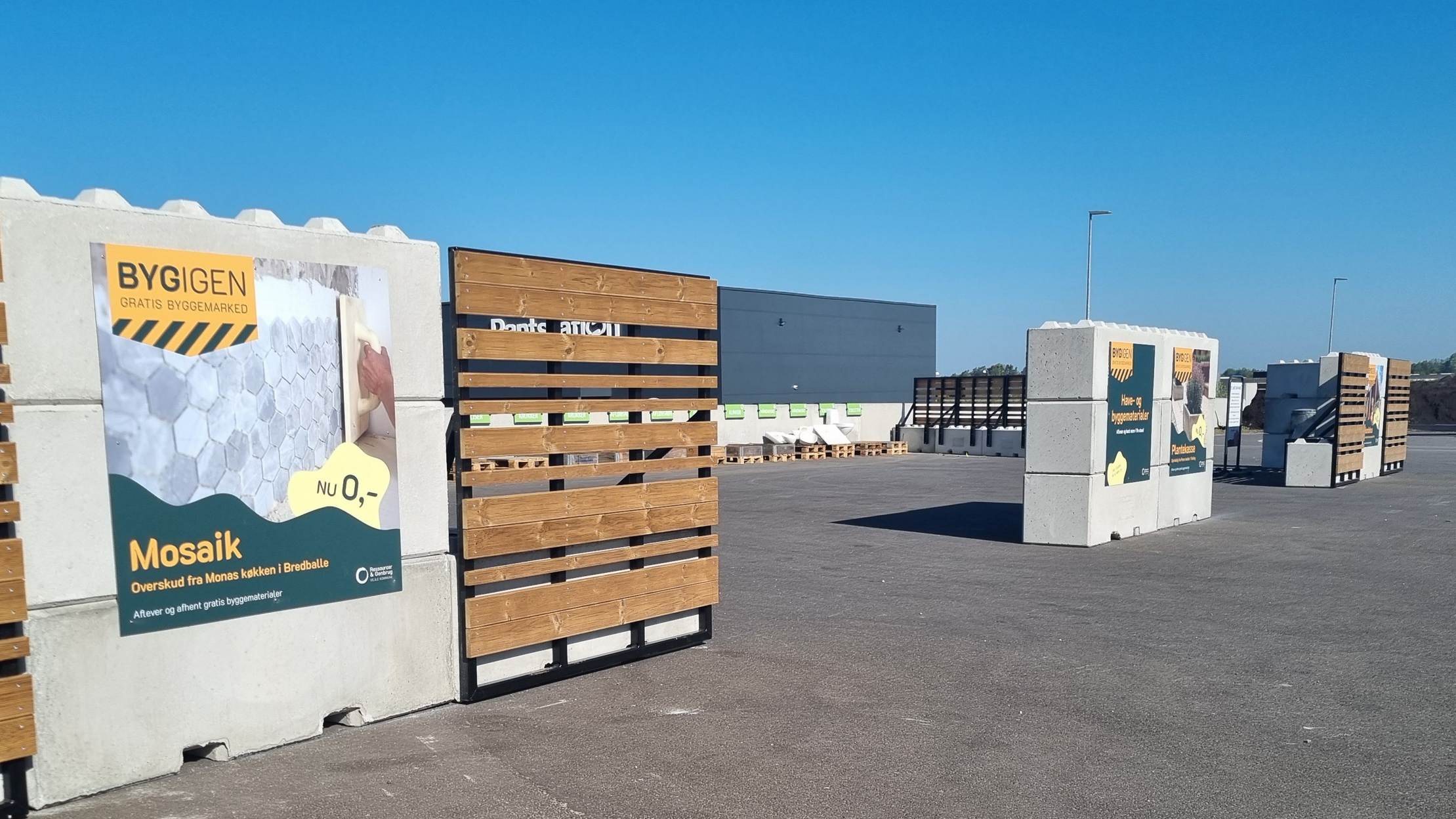 Foto af BygIgen-området på RessourceCenter Vejle. Området består af sektioner med gratis byggematerialer som fliser og tegl, hvor borgere kan aflevere og hente overskudsmaterialer