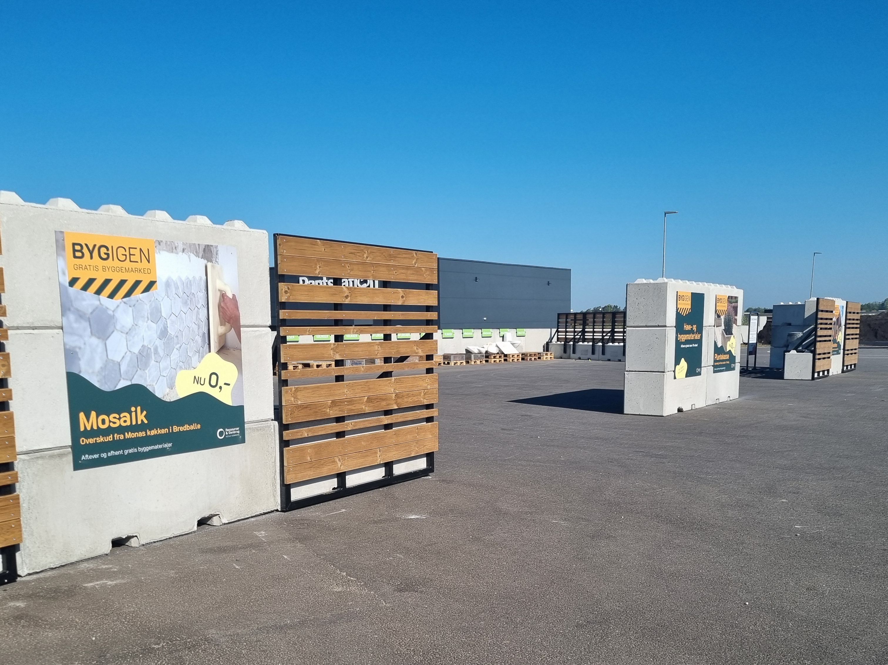 Foto af BygIgen-området på RessourceCenter Vejle. Området består af sektioner med gratis byggematerialer som fliser og tegl, hvor borgere kan aflevere og hente overskudsmaterialer