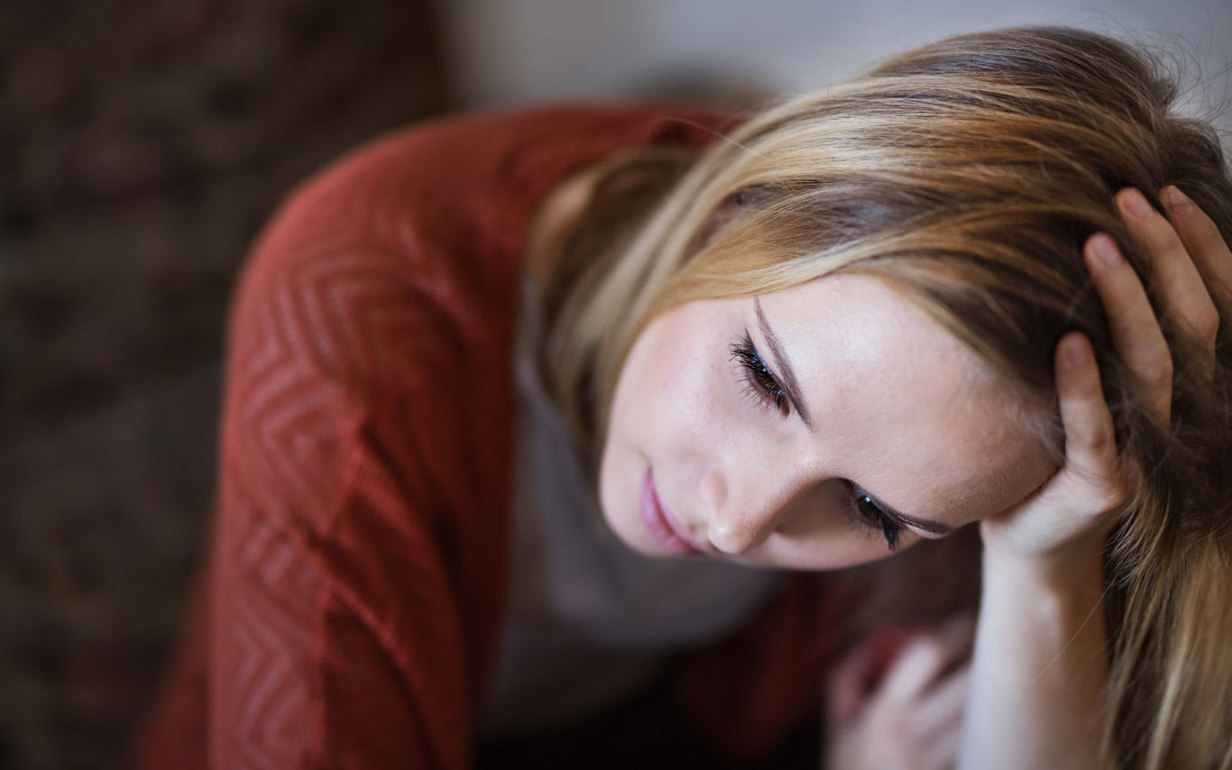 Portræt af ung kvinde der hviler sit hoved i den ene hånd