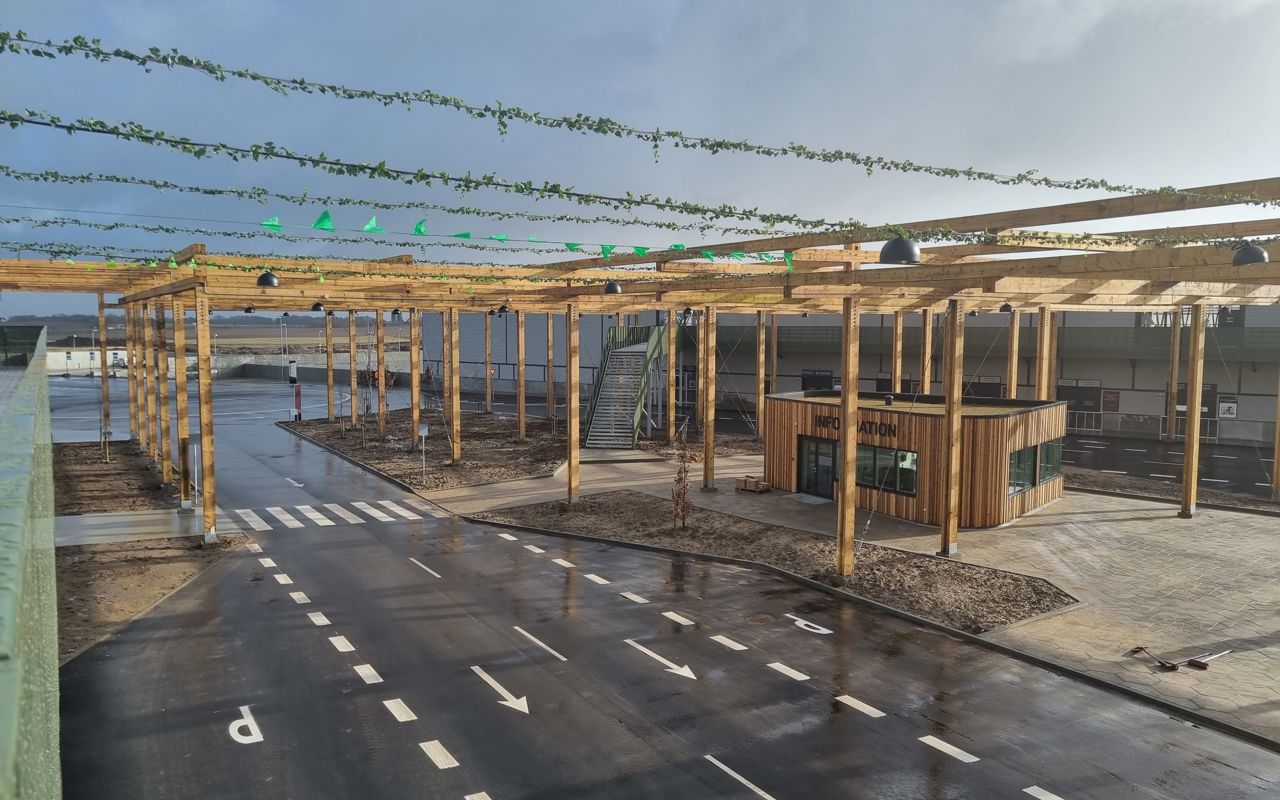 Udsigt over genbrugspladsen ved RessourceCenter Vejle. Området har brede vejbaner med tydelige markeringer og et informationstårn i trædesign