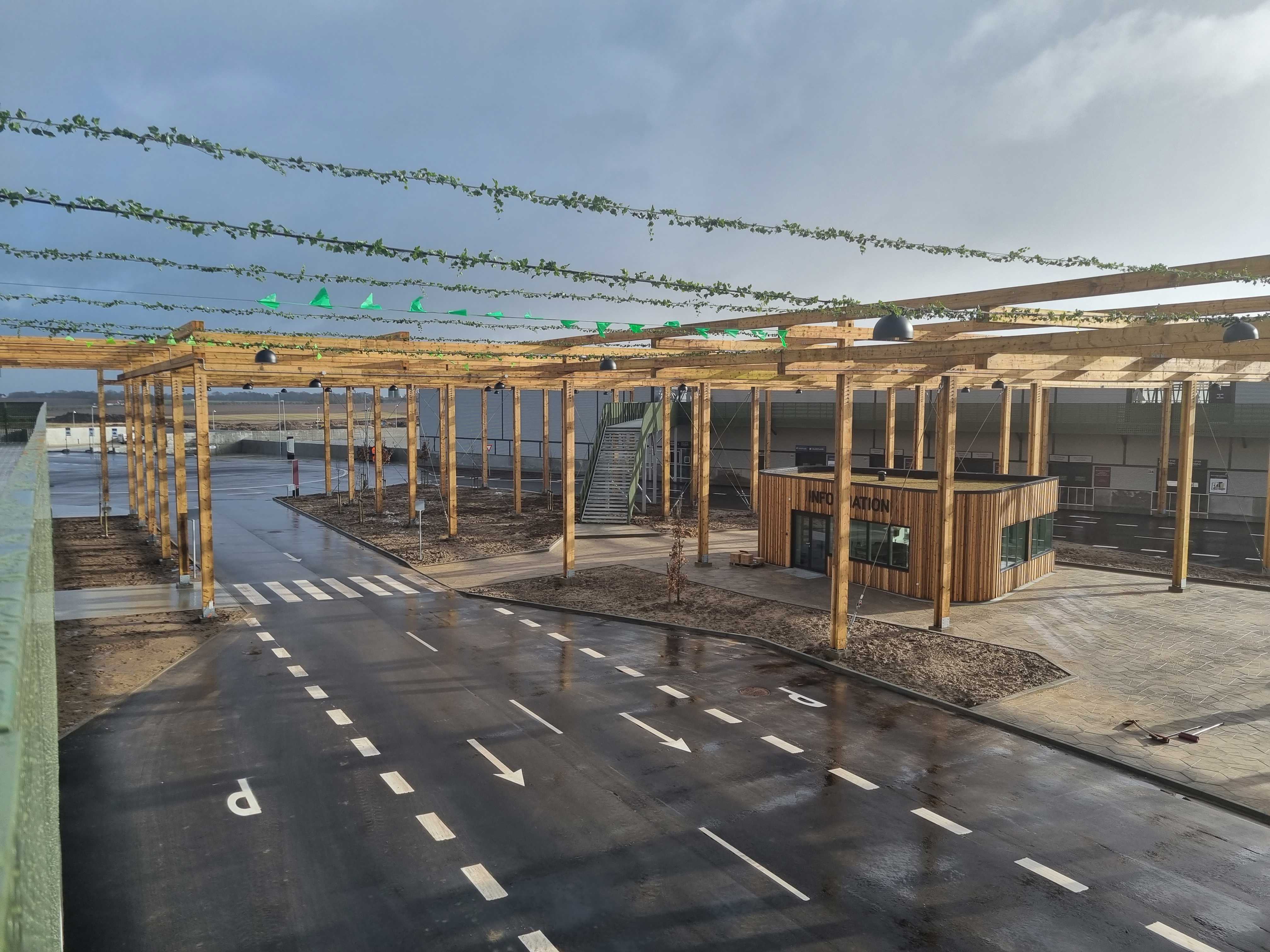 Udsigt over genbrugspladsen ved RessourceCenter Vejle. Området har brede vejbaner med tydelige markeringer og et informationstårn i trædesign